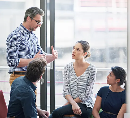 Communication Training Facilitator coaches a small team through a communication exercise, building conversation skills for Leadership & Team Effectiveness
