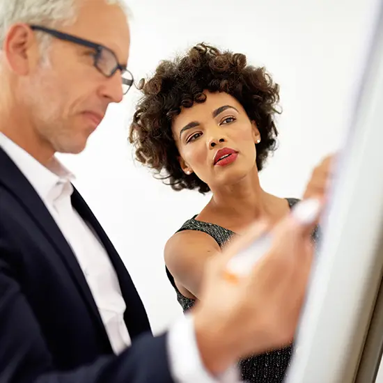 Executive and Leadership Coaching One-on-one executive coaching at a whiteboard, coach guiding a leader with practical leadership development for decision making and communication
