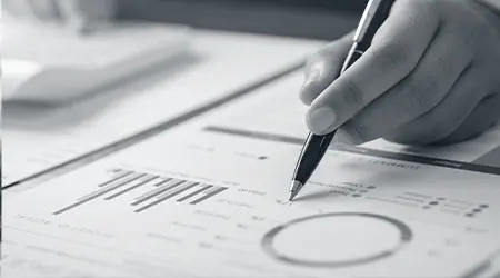 Close-up of a person reviewing organizational analytics and performance charts with a pen — representing AI integration for organizational effectiveness
