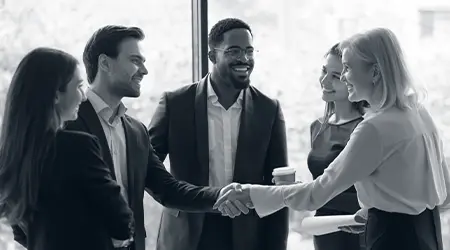Diverse business team shaking hands during a strategy meeting for business process optimization and system redesign