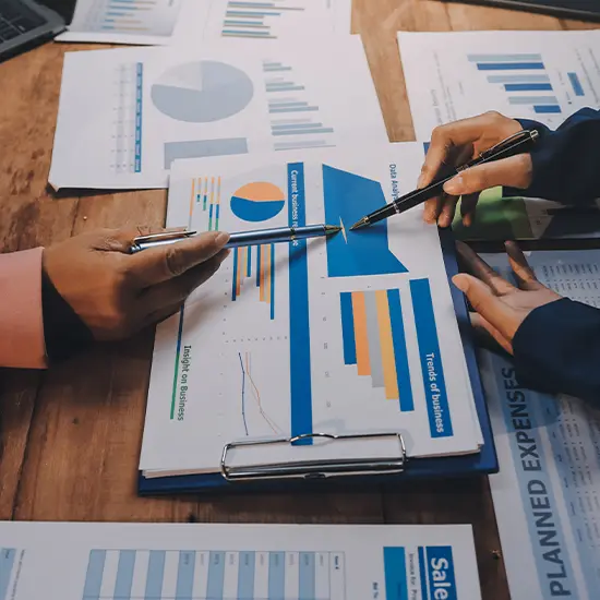 Team reviewing market charts and trends during strategic research consulting and organizational assessment