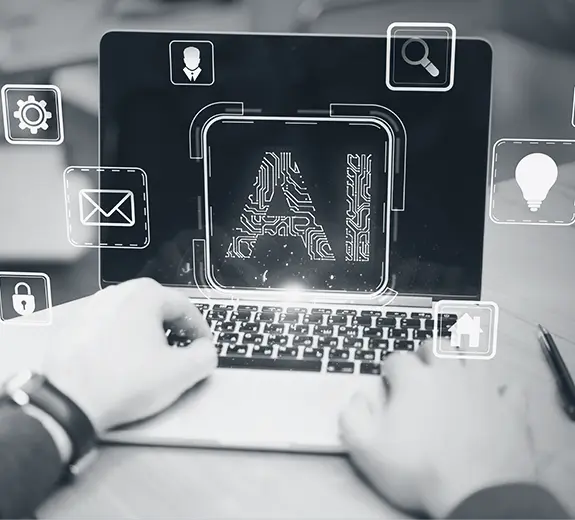 Person using a laptop with AI icons on screen while evaluating which AI tools actually help as part of AI integration consulting for organizations