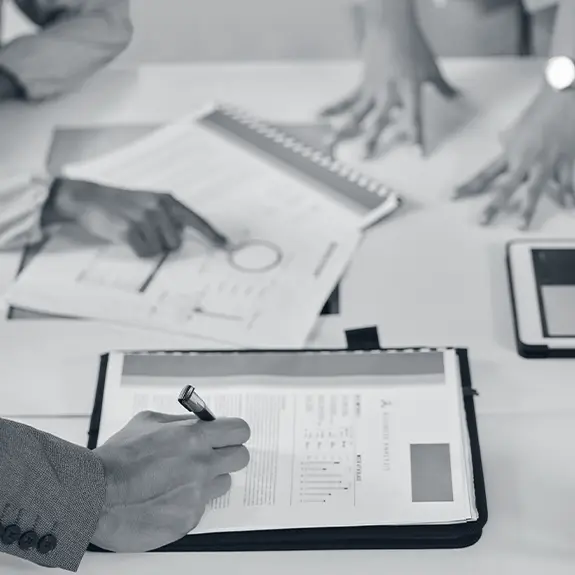 Consultants conducting stakeholder research and feasibility study review with documents and charts