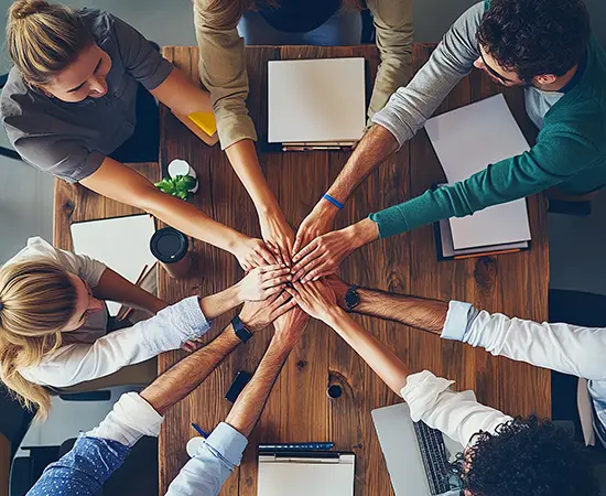Team Effectiveness Work Team stacking hands in a working session to confirm collaboration and working agreements for Leadership & Team Effectiveness