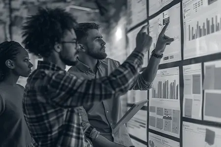 Diverse consulting team reviewing data dashboards to detect bias in organizational systems.