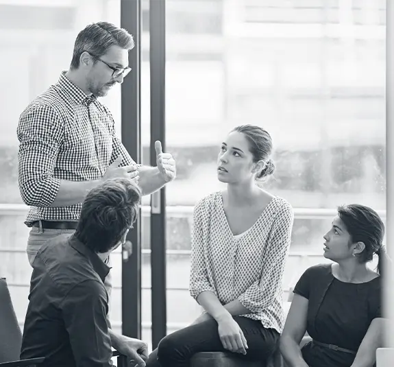 Facilitator leading communication training with a small group of professionals in a meeting room