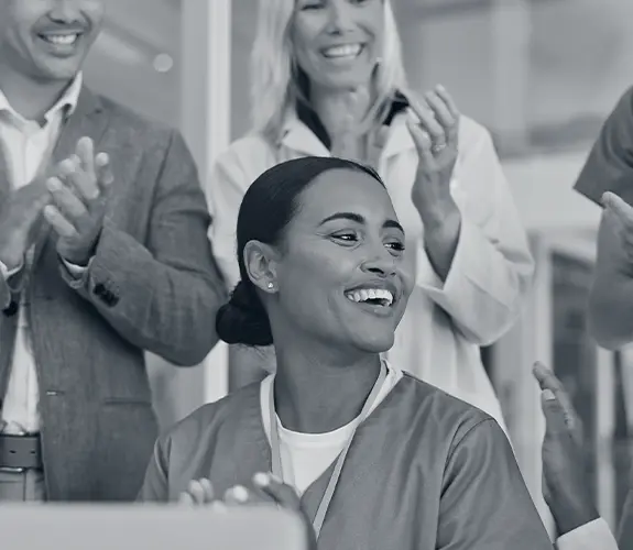 Team celebrating a colleague’s success, showing the impact of effective leadership and teamwork