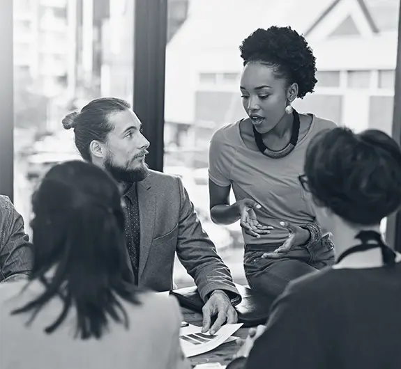 Team leader facilitating a discussion with colleagues in a modern office