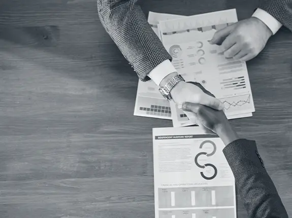Hands pointing to strategic research findings and organizational assessment reports